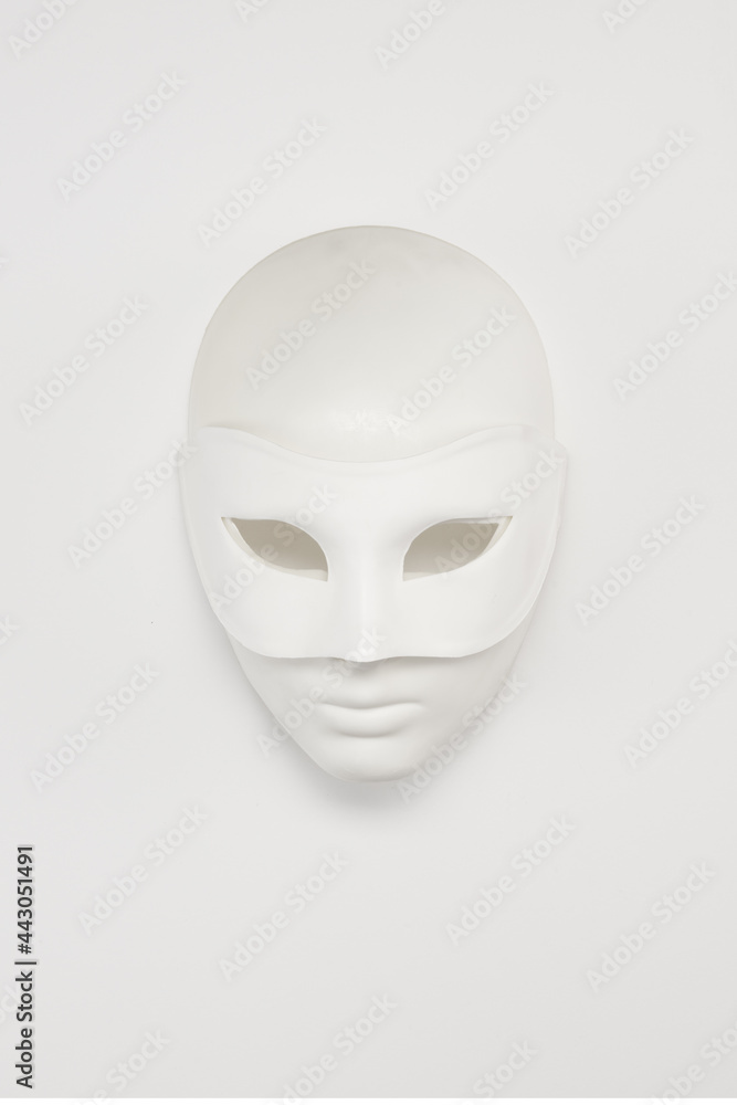 White venetian or theatrical masks on a background. High key White venetian or theatrical masks on a background. High key