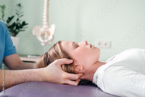 A girl receiving CST treatment by osteopath practitioner using gentle hands-on technique, central nervous system tension relieve