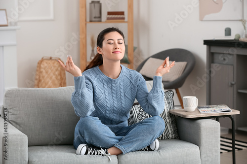 Young woman meditating at home