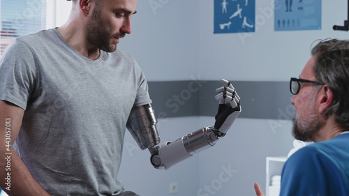 Foto Happy patient learning to use bionic arm near doctor