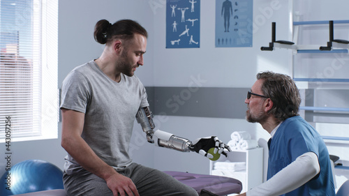 Fotografie Doctor teaching patient to use prosthetic arm