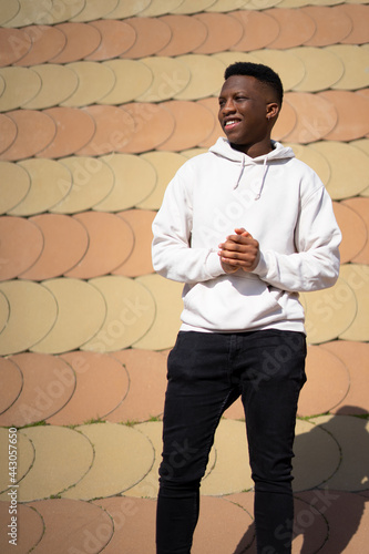 Portrait of handsome black young man in white sweater with cheerful attitude