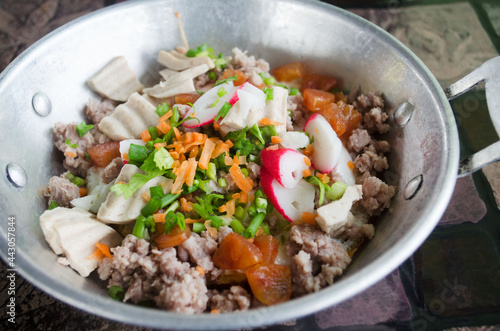 Thai local style breakfast meal well known as Khai Krata, or fried egg pan with pork chopped, sausage, and meat loaf topping with carrot and leek