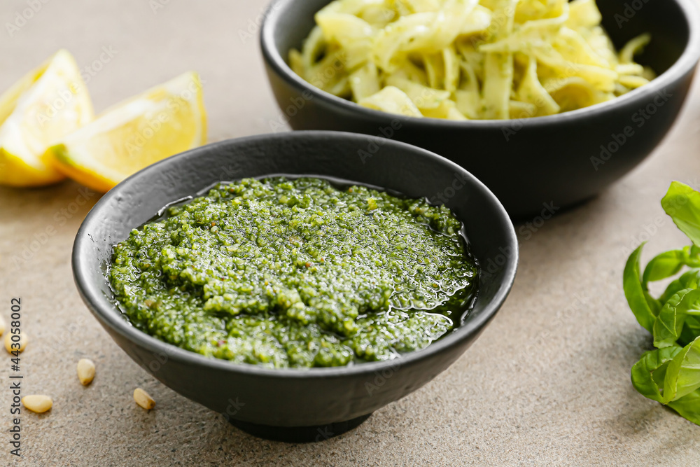 Bowl of tasty pesto sauce on table