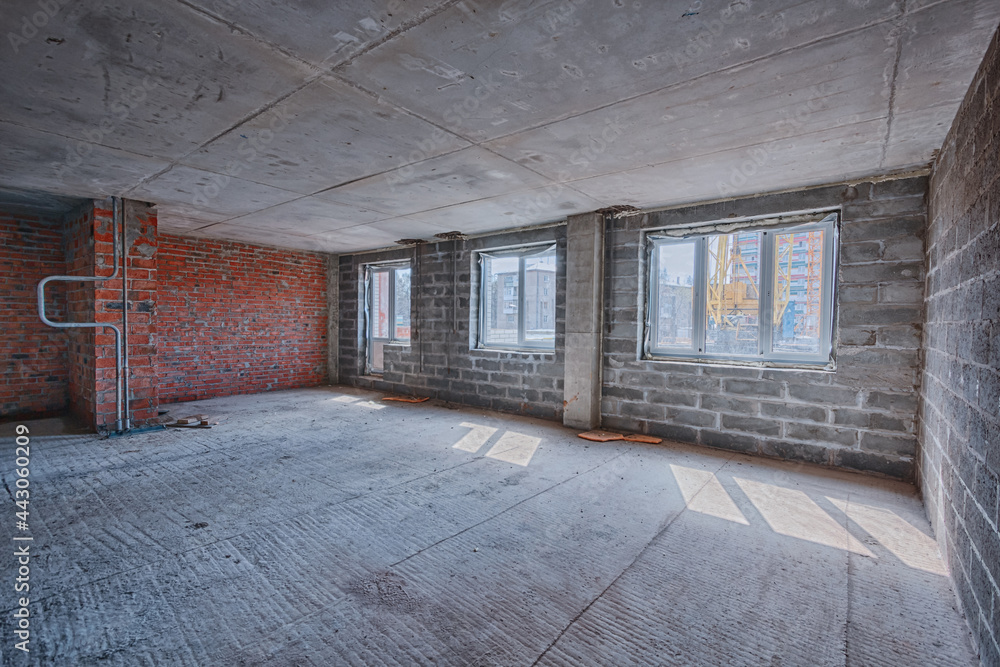 Obraz premium Apartment interior without finishing. Room in new building without repair, walls are not plastered. Repair works on construction site of residential apartment.