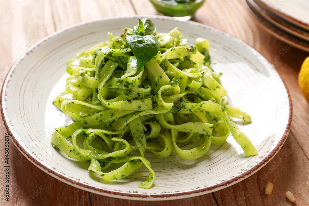 Plate with tasty pesto pasta on table