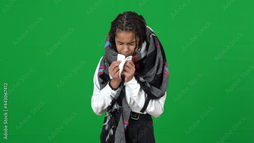 Front view of sad ill teenage girl sneezing on green screen looking at camera with upset facial expression. Portrait of sick African American teen posing at chromakey background. Illness and medicine Front view of sad ill teenage girl sneezing on green screen looking at camera with upset facial expression. Portrait of sick African American teen posing at chromakey background. Illness and medicine
