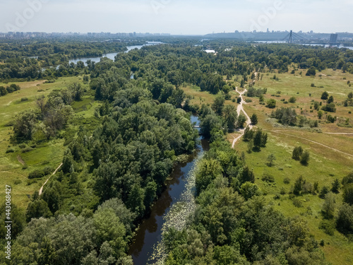 River among green trees in summer. Aerial drone view.