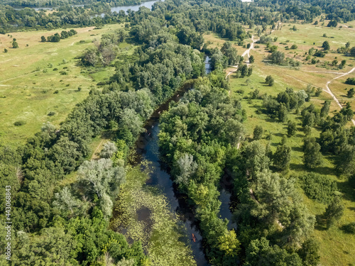 River among green trees in summer. Aerial drone view. © Sergey