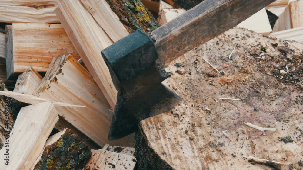 Big old wooden ax chops down tree trunks on the background of a cut log Big old wooden ax chops down tree trunks on the background of a cut log