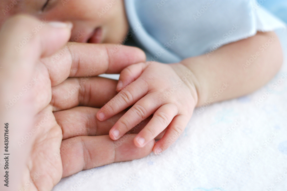 Newborn baby hand with father hand