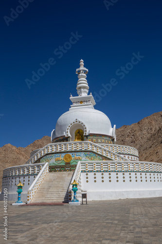 White buddhist stupa or pagoda in tibetan monastery near village Leh in ladakh, noth India photo