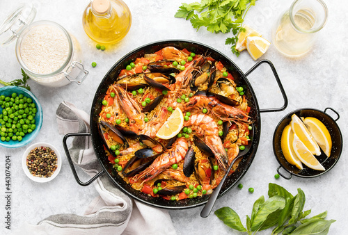 Seafood paella ready to eat served in a paella pan, top-down view photo