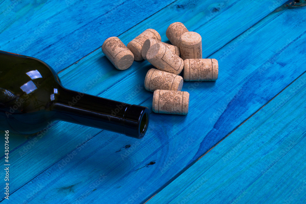 Bottle of red wine and corks on wooden table