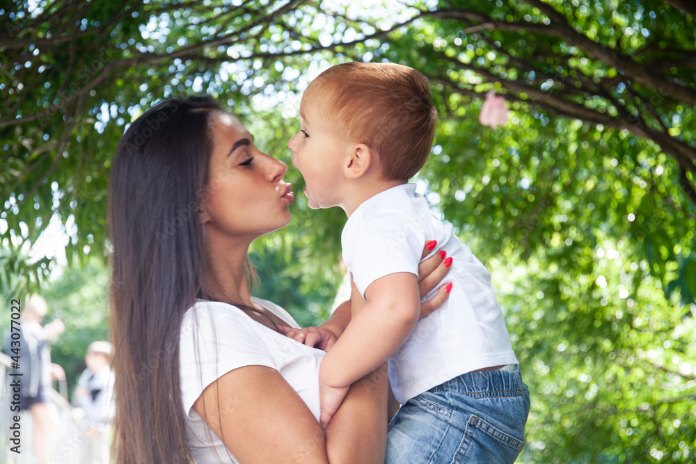young pretty brunette mother with little cute boy walking in park happy smiling, lifestyle people concept young pretty brunette mother with little cute boy walking in park happy smiling, lifestyle people concept