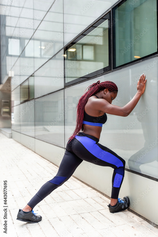 Woman leaning at wall during workout Woman leaning at wall during workout