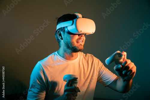 young man wearing Virtual Reality VR Headset. VR for gaming. Man play game in VR glasses. Hipster with virtual reality headset. 