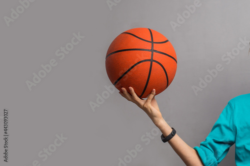 child with basketball ball over grey background © PEPPERSMINT