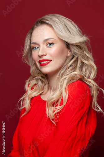 Happy woman with perfect makeup smiling on red background