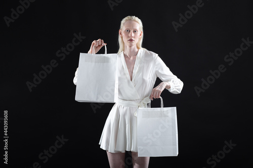 White caucasian albino blond woman holds shopping bag. Sale and discounts on market and Black Friday concept.