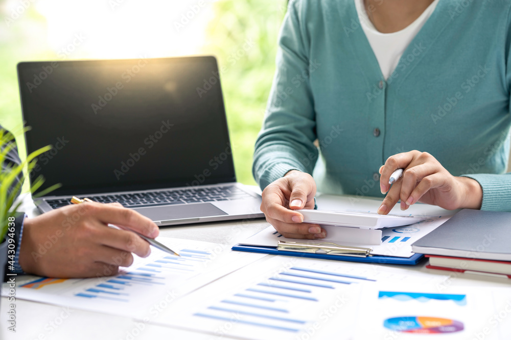 Financial inspector calculating numbers in office room, Woman accountant use calculator and computer with holding pen on desk in the office. finance and accounting concept Financial inspector calculating numbers in office room, Woman accountant use calculator and computer with holding pen on desk in the office. finance and accounting concept