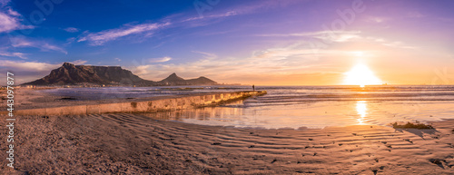 Scenic vista of Table Mountain, Cape Town, South Africa. A stunning view from Table View beach - across the bay where tourists and surfers alike come to enjoy the beach and ocean.