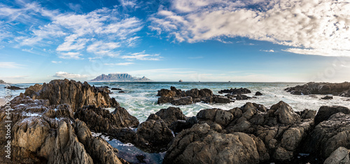 Scenic vista of Table Mountain, Cape Town, South Africa. A stunning view from Table View - across the bay where tourists and surfers alike come to enjoy the beach and ocean.