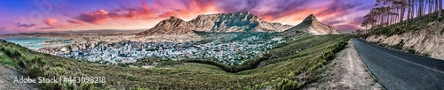 Dramatic and colourful sunset panorama of Table Mountain and the city bowl area, Cape Town South Africa. A unique wide-angle perspective from Signal Hill road  including some forest environment
