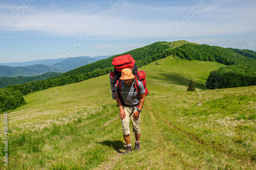A tourist with a large backpack walks along the Carpathian mountain range in Ukraine
