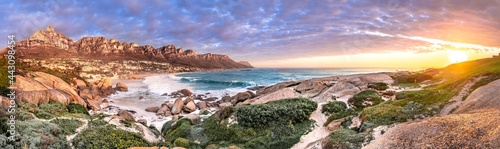 Breathtaking sunset panorama of the iconic Table Mountain and the Twelve Apostles range, Cape Town South Africa. A unique and scenic wide-angle perspective taken from Maidens cove photo