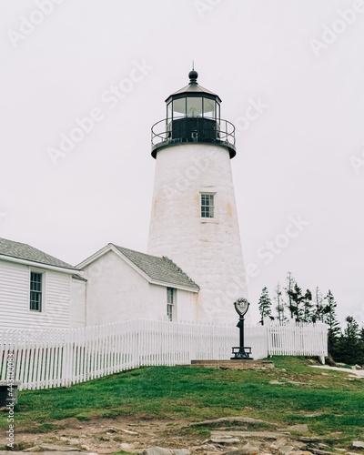 A white lighthouse with a white fence - Pemaquid Point Lighthouse in Bristol, Maine