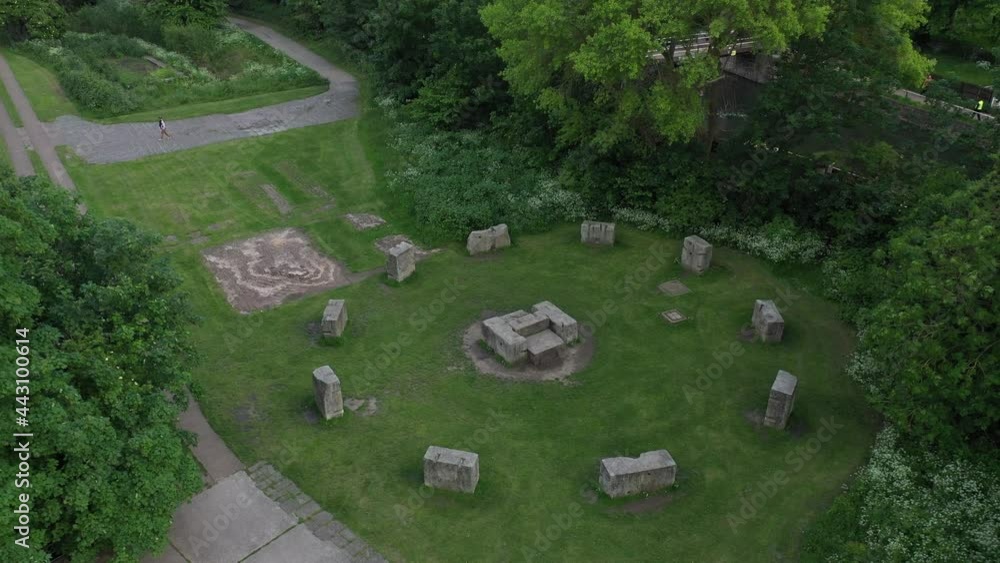Large stone blocks arranged in circle standing on lawn in park. Ascending footage of old sanctuary Large stone blocks arranged in circle standing on lawn in park. Ascending footage of old sanctuary