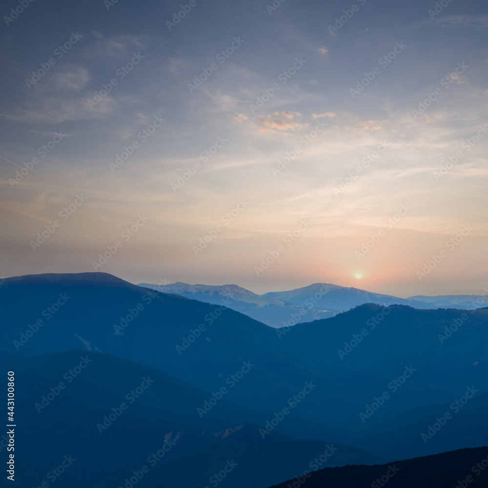 mountain chain silhouette in blue mist at the early morning
