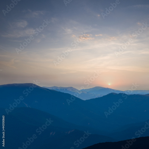 mountain chain silhouette in blue mist at the early morning