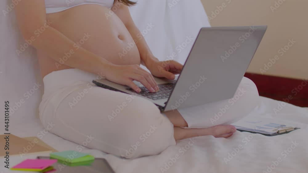 Slow motion of Pregnant business woman sitting and working on the laptop with sale report,tablet,books and sticky note at home,Pregnant of businesswoman typing on laptop,Business and Pregnancy Concept Slow motion of Pregnant business woman sitting and working on the laptop with sale report,tablet,books and sticky note at home,Pregnant of businesswoman typing on laptop,Business and Pregnancy Concept
