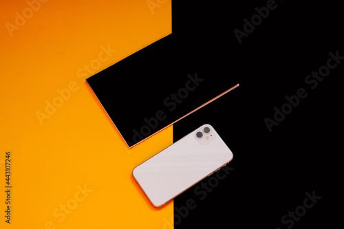Close up glass, phone, notebook and mint on colors background 