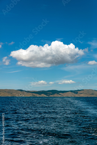 Rocky land, rippled sea, cloud on clear blue sky. Aegean sea, Cyclades © Rawf8