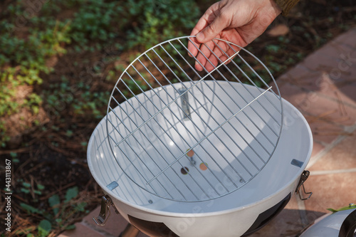 Hand sets grill in round barbecue photo