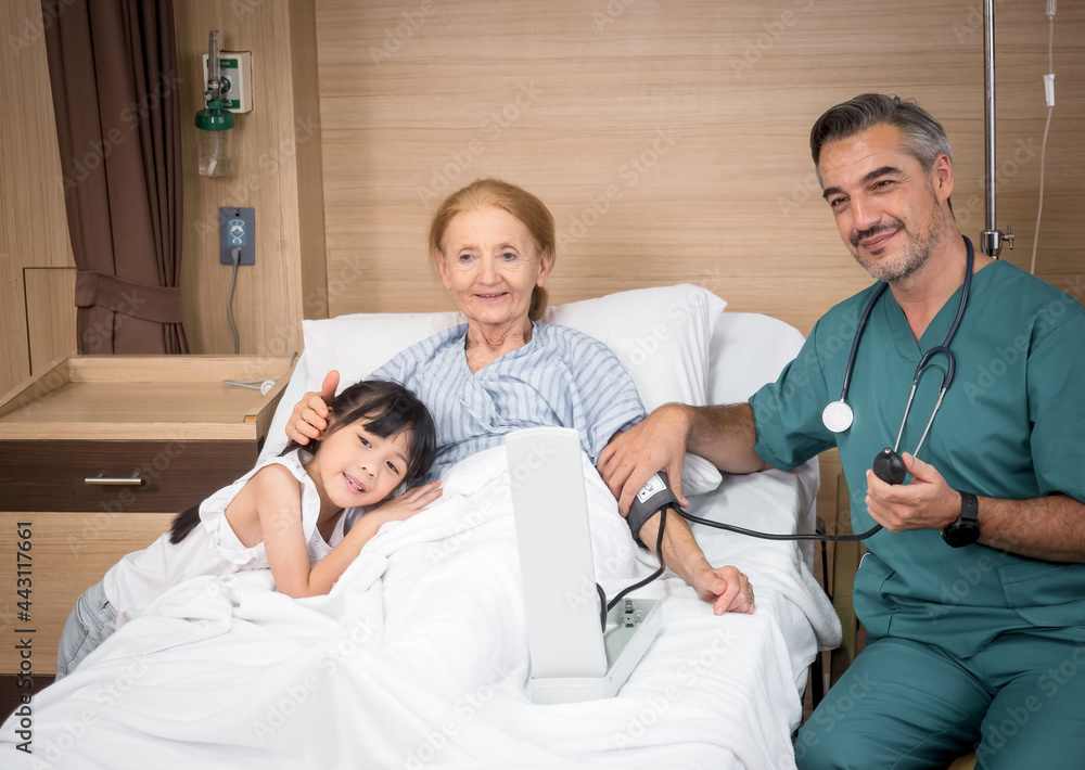 Obraz premium Doctor with a cute little girl and elderly female patient showing thump up OK signs in hospital. Medicine and health care concept..