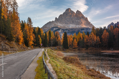 Majestic autumn landscape,alpine glacier lake and yellow pine trees, Antorno lake with famous Tre Cime di Lavaredo peaks in background