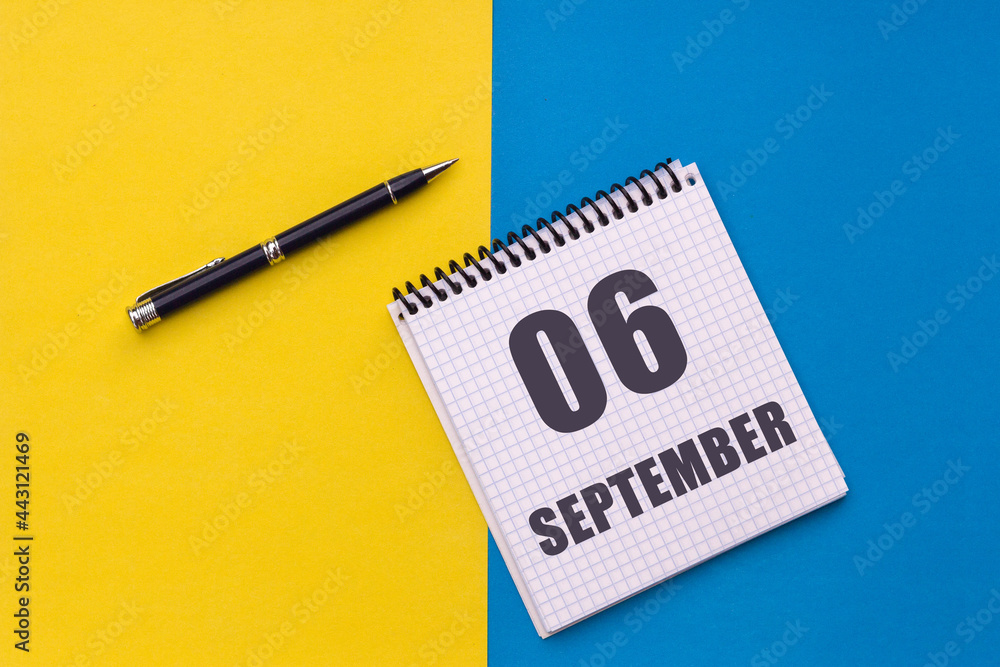 September 6th. Day 6 of month, calendar date. Notebook with a spiral and pen lies on a yellow-blue background September 6th. Day 6 of month, calendar date. Notebook with a spiral and pen lies on a yellow-blue background