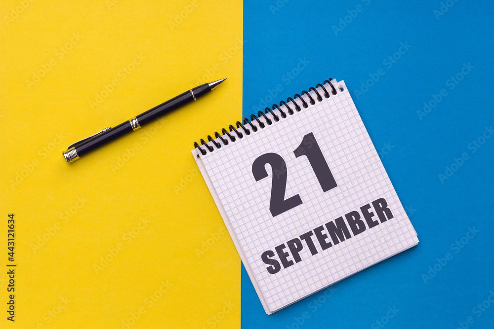 September 21th. Day 21 of month, calendar date. Notebook with a spiral and pen lies on a yellow-blue background September 21th. Day 21 of month, calendar date. Notebook with a spiral and pen lies on a yellow-blue background