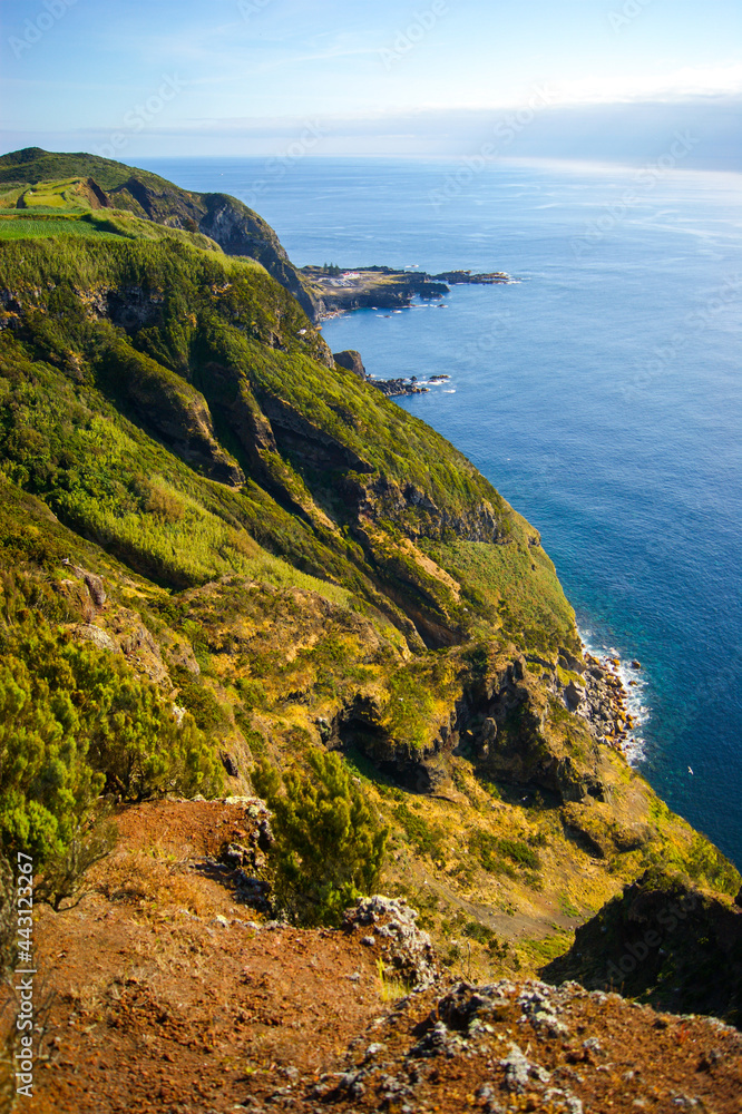 Green coastal cliffs touching the blue ocean in Sao Miguel island, Azores.