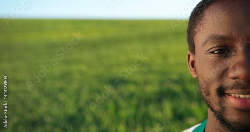Half portrait view of the multiracial professional happy farmer standing in backyard of organic farmhouse and smiling with joy. Farming business and agriculture concept