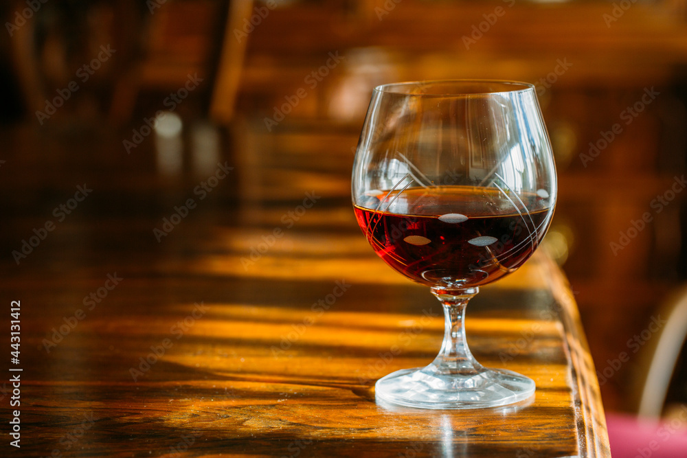Cognac glass on wooden table with natural light Cognac glass on wooden table with natural light