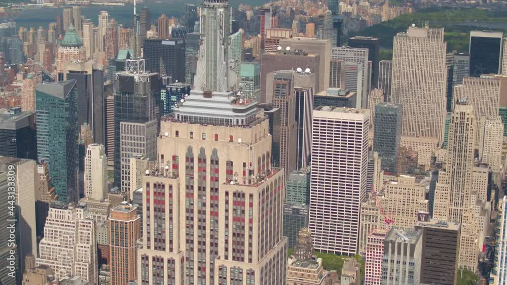 AERIAL: Flying around Empire State Building and adjacent skyscrapers on a sunny fall day in scenic New York City. Spectacular heli shot of the historic Empire State Building in bustling downtown NYC.