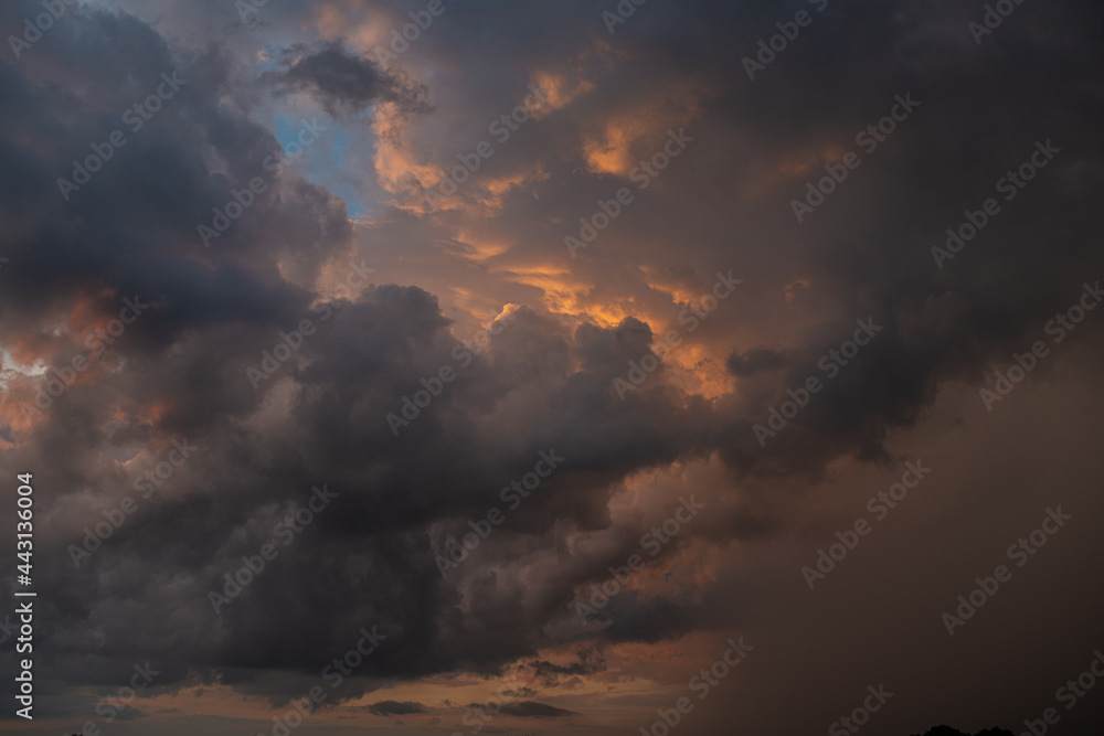 a dark thundercloud on the background of sunset