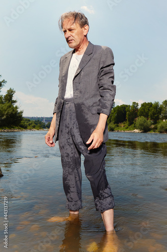 Manager in grey suit became crazy of hot weather and cooling in river photo