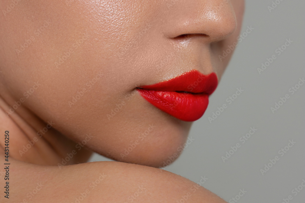 Fototapeta premium Close-up of woman's lips with fashion bright red make-up. Beautiful female mouth, full lips with perfect makeup. Part of female face. Choice lipstick