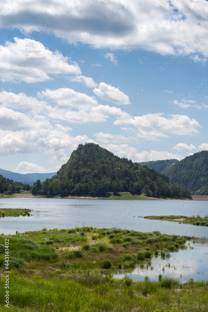 Panorama of the Kruth lake in France on blue cloudy sky background